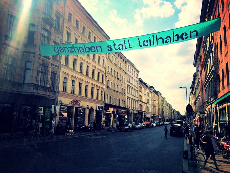 Banner über der Oranienstraße mit der Aufschrift "ganzhaben statt teilhaben"