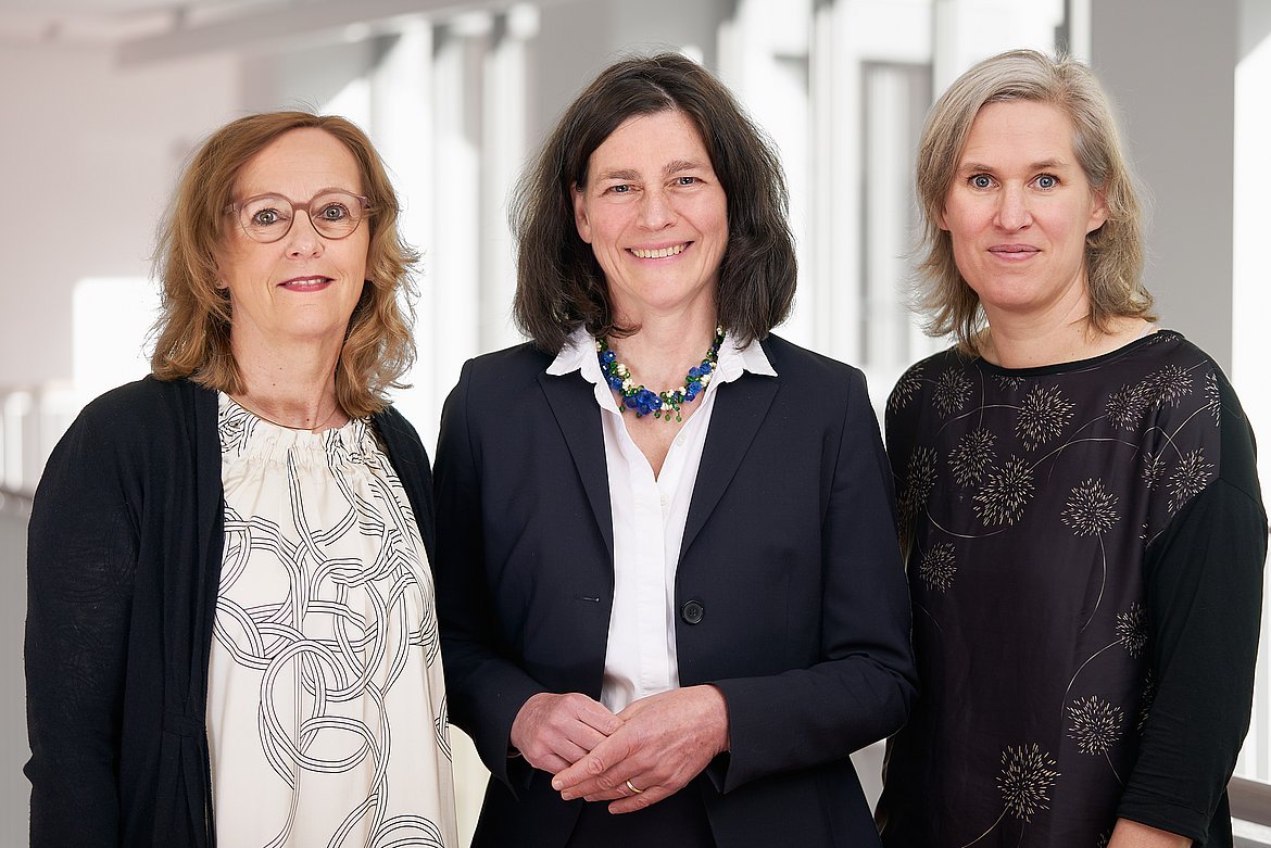 Gruppenfoto der ASH-Hochschulleitung. Im Hintergrund ist die Fensterfront des ASH-Treppenhauses zu sehen. 