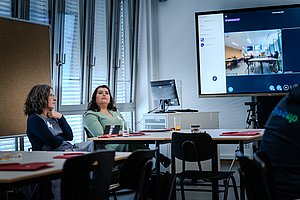 Zwei Frauen blicken während eines Workshops auf Monitore.