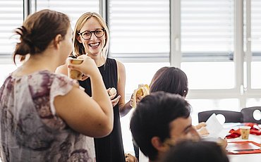 Gespräch zwischen zwei Kommilitoninnen des Master of Arts Studiengangs Intercultural Conflict Management Studierende lacht in die Kamera