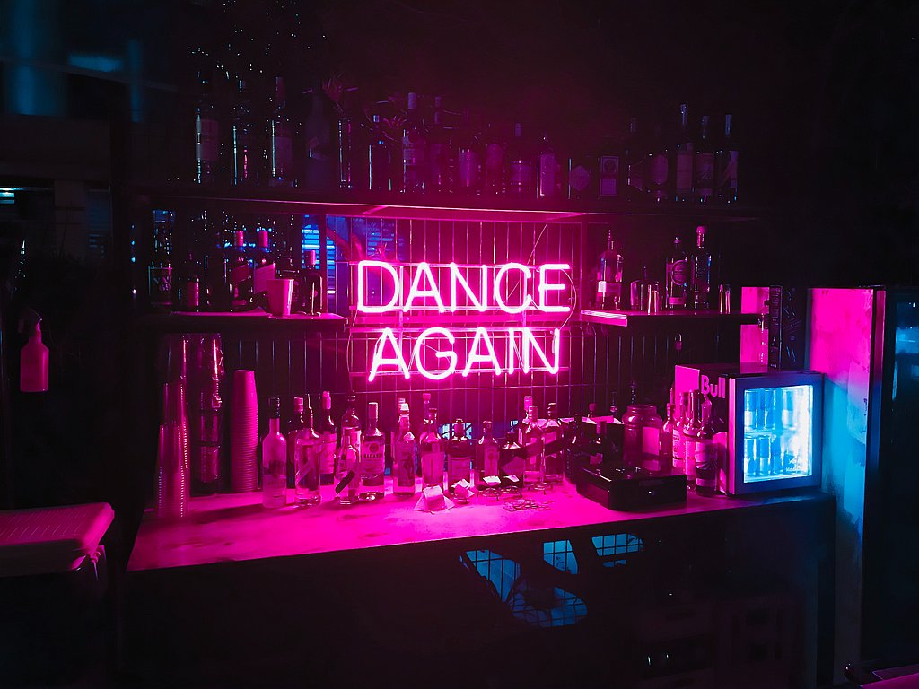 Bar mit Leuchtreklame "Dance Again"