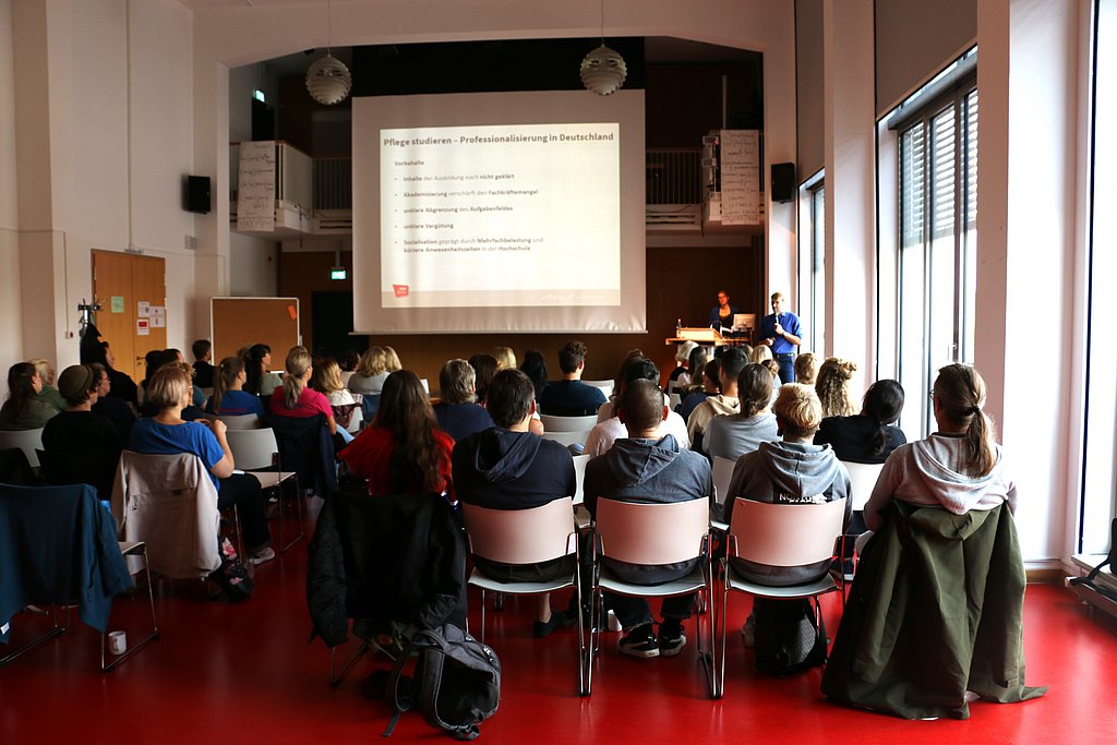 Foto vom Audimax in dem ungefähr 70 Personen sitzen und einem Vortrag zuhören